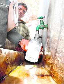 Another health worker takes a water sample from a government school at jaundice-affected Kotli Than Singh village.