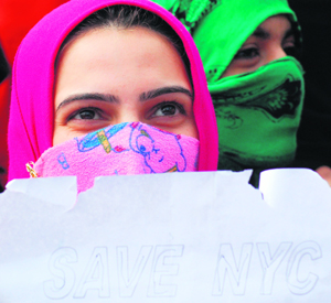 A volunteer from the National Youth Corps displays a placard during a protest against the state government in Srinagar on Monday.