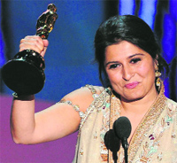 Sharmeen holds up her trophy onstage. 