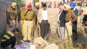Officials inspect the foetus found at Kumbra village, Mohali, on Tuesday. 