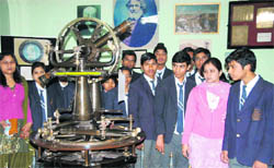 Students watch scientific equipment during an exhibition organised by the Survey of India on National Science Day in Dehradun