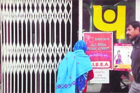 A woman stands outside a branch of Punjab National Bank during a nationwide strike in Shimla on Tuesday