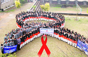 Volunteers form the red ribbon sign during an HIV/AIDS awareness campaign in Dharamsala.