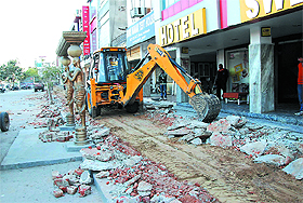 A JCB machine at work outside a hotel on the Bathinda-Goniana road to make way for constructing a pavement, on Thursday.