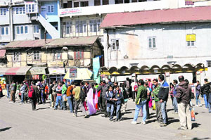 People wait for HRTC buses as private bus operators observe a one-day strike in protest against the hike in taxes in Shimla on Thursday