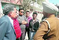 Police officials listen to the details of the robbery incident that took place on the Rahon road on Wednesday