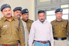 Ravi Malik, one of the accused in the shooting case of BSP candidate from Mussoorie Manoj Sharma, in police custody in Dehradun on Friday. 