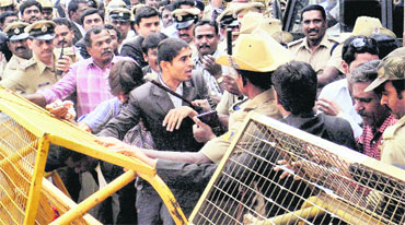 Police personnel try to control the situation during a clash between lawyers and mediapersons on the Civil Court premises in Bangalore on Friday.
