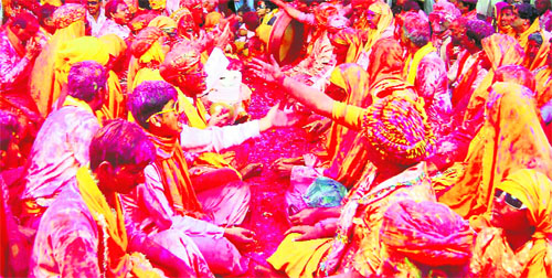 Devotees sing folk songs during Holi celebrations at Sriji temple in Barsana on Friday.