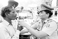 A police personnel uses the alcometer on a truck driver in Patiala