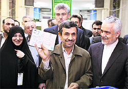 Iranian President Mahmoud Ahmadinejad (C) shows his identification document after casting his vote for the parliamentary elections, while Vice-President Mohammad Reza Rahimi (right) looks on in Tehran on Friday