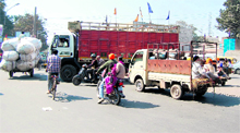 Entry of heavy vehicles such as trucks, continues unabated despite a ban leading to frequent traffic jams, besides posing a threat to the lives of commuters and (below) a private bus caught in the traffic jam at a railway crossing in Amritsar. 