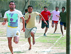 Students of the Education Department of Punjabi University Regional Centre participate in three-legged race and (right) run during a track event organised at the annual athletic meet in Bathinda on Saturday