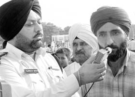 A policeman uses an alcometer