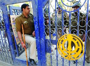 Delhi police personnel keep a vigil on the gate of Bala Sahib Gurdwara in New Delhi on Saturday. 