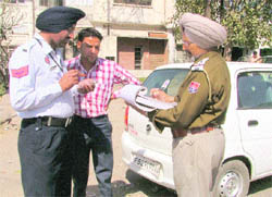 Traffic cops challan a car driver and a motorcyclist for traffic violation in Ludhiana