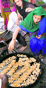 Girl students prepare jalebies during the annual Akhandpath organised before the examination at the Government Girls College in Patiala on Saturday