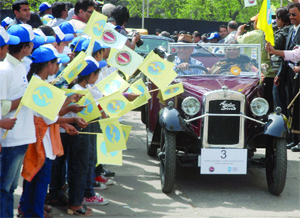 Children suffering from cancer cheer participants of the Vintage Car and Motorcycle Drive against Cancer in New Delhi on Sunday. 