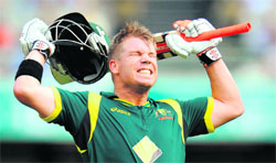 Australias David Warner celebrates his century against Sri Lanka in the first final at the Gabba in Brisbane on Sunday.