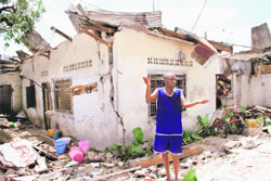 A man gestures in front of houses damaged in a series of explosions at a munition depot in the Congolose capital of Brazzaville on Sunday. 