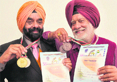 Gurjiwan and Pargat Singh Sidhu pose with their medals won during the National Masters Athletics Championship, in Chandigarh, on Saturday.