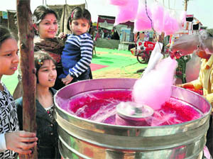 Children wait for their turn to get candyfloss at Leisure Valley in Gurgaon.