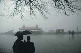 Students with umbrellas during a sudden spell of rain in Shimla on Monday