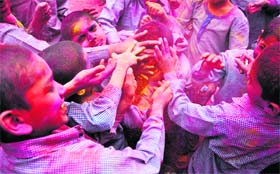 Children of Bal Bhawan smear colours on a mate at a Holi celebration function in Ludhiana on Monday
