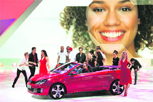 Models surround the new Volkswagen Golf GTI Cabriolet car during the first media day of the 82nd Geneva Auto Show at the Palexpo in Geneva, Switzerland on Tuesday. Some 700 carmakers are holding press previews of their newest batch of automobiles at the show, which will be open to the public from March 8 to 18.