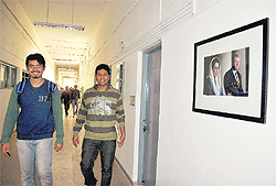 Students walk across a photograph of Benazir Bhutto and Bill Clinton during the shooting of Zero Dark Thirty at PEC in Chandigarh on Tuesday. 