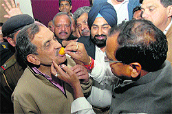 Yashpal Arya, state Congress chief, offers a ladoo to Birender Singh, general secretary and in charge of the party affairs, in Dehradun on Tuesday. 