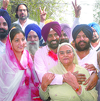 SAD candidate from Jalandhar Cantonment Pargat Singh hugs his mother as his wife and supporters look on after declaration of results on Tuesday. 