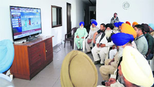 Supporters watching election updates in Ludhiana. 