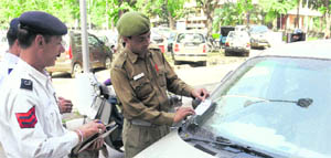 Policemen paste a challan slip on a car at Sector 17 in Chandigarh on Wednesday