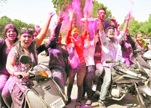 Students throw gulal into the air at Panjab University in Chandigarh on Wednesday. 