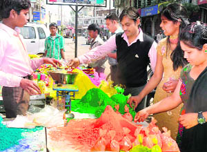 People buy colours for Holi in Haridwar on Wednesday. 