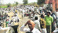 Jat protesters block the rail track at Ramayan village in Hisar district on Wednesday; and (inset) firing victim Sandips body 