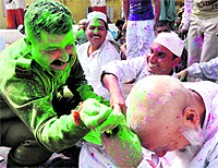 A policeman applies colour to one of the inmates of the District Jail, Amphla, in Jammu on Wednesday