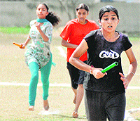 Girls take part in a relay race during the annual athletics meet of Satguru Ram Singh Government Polytechnic College in Ludhiana on Wednesday