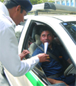 A Delhi traffic police official checks a taxi driver to see if he is drunk on Holi day in New Delhi. 