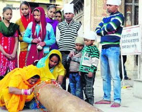 Women pray before the mast to be erected during the Jhanda Mela at Guru Ram Rai Darbar in Dehradun on Friday. 