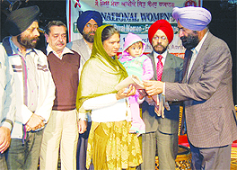 Satnam Kaur, who refused to abort her girl child, being honoured by district health officials during Womens Day celebrations at Virsa Vihar in Amritsar on Saturday. 