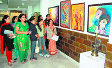 Residents take a look at paintings during an exhibition at KT Kala in Amritsar on Saturday. 