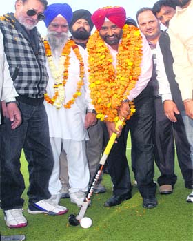 Olympian Pargat Singh dribbles a ball with a hockey stick during a function to honour him after his victory in the Punjab Assembly elections at Sansarpur Astroturf in Jalandhar Cantonment