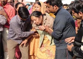 Gora Lal Gargs wife being consoled by friends and family members