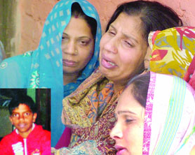 The aggrieved mother and relatives of Tarun Chauhan (inset), who was shot dead at Dhaka village in the Mukherjee Nagar area of North Delhi on Monday.