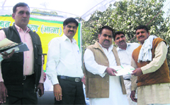 Sonepat MP Jitender Singh Malik gives away a cash reward to a farmer at the Kisan Mela in Sonepat