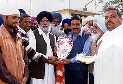 City jewellers association president, Manmohan Singh Kukku, presenting a bouquet to the newly-elected MLA Sikandar Singh Maluka at Maluka village