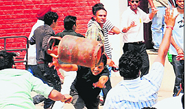 A student throws an LPG cylinder during a clash at DAV College in Sector 10, Chandigarh