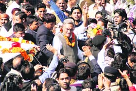 Chief Minister Vijay Bahuguna being greeted by Congress supporters on his arrival in Dehradun on Tuesday